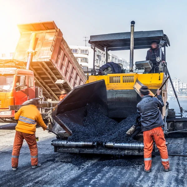 Workers making asphalt with shovels at road constructio — Stock Photo, Image