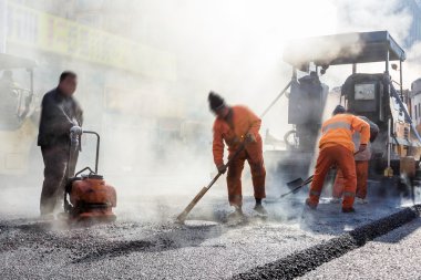 İşçiler asfalt yol yapı, kürek ile yapma