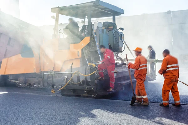Workers making asphalt with shovels at road constructio — Stock Photo, Image