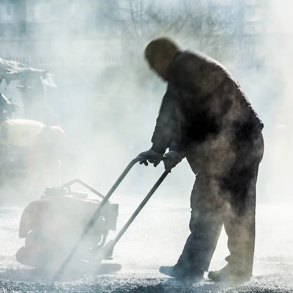 道路建設でシャベルでアスファルトを作る労働者 — ストック写真