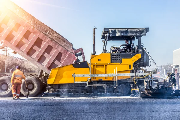 Trabajadores haciendo asfalto con palas en constructio carretera —  Fotos de Stock