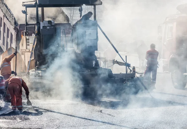 Workers making asphalt with shovels at road constructio — Stock Photo, Image