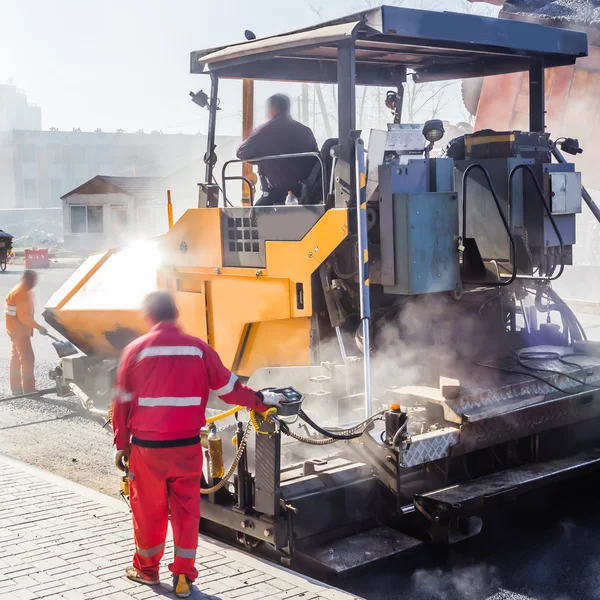 Workers making asphalt with shovels at road constructio — Stock Photo, Image