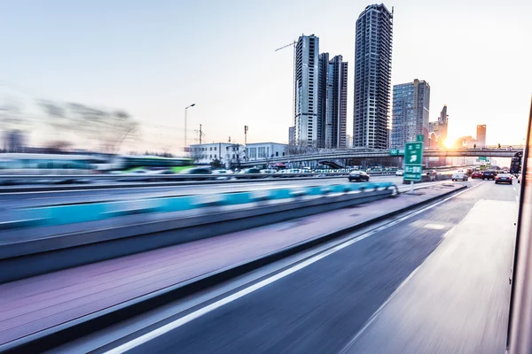 Coche conduciendo en la autopista al atardecer, desenfoque de movimiento —  Fotos de Stock