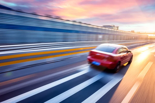 Auto rijden op de snelweg bij zonsondergang, bewegingsvervaging — Stockfoto