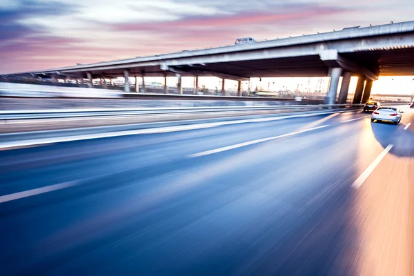 Gün batımında otoyolda giden araba, hareket bulanıklığı 