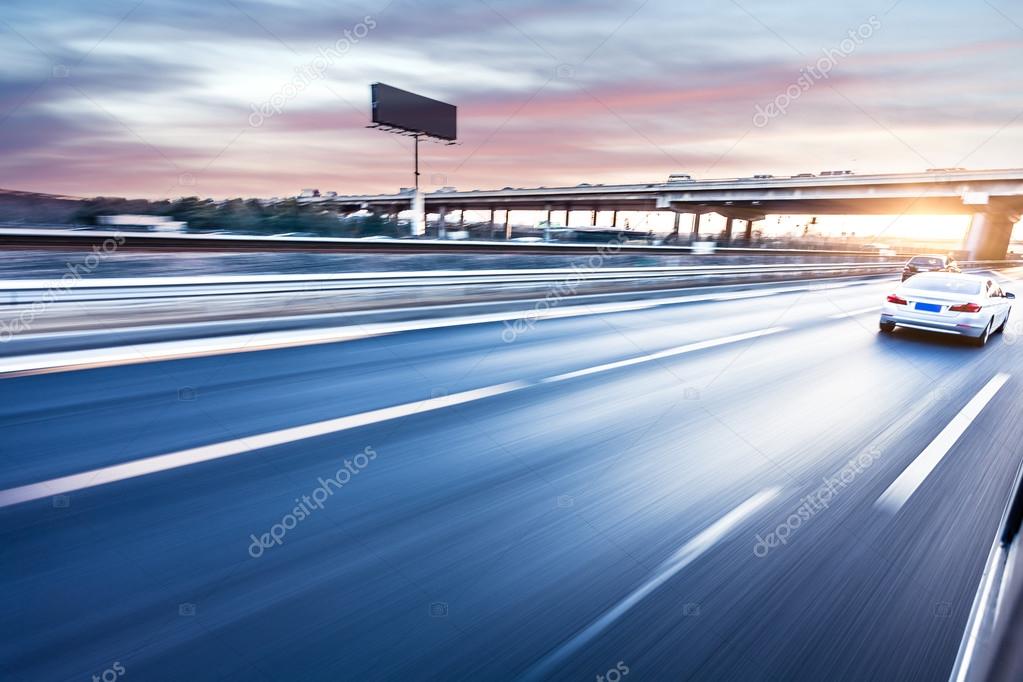 Car driving on freeway at sunset, motion blur 