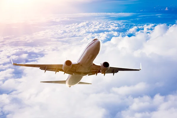 Airplane in the sky at sunrise — Stock Photo, Image