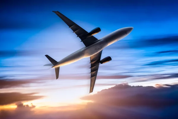 Airplane in the sky at sunrise — Stock Photo, Image