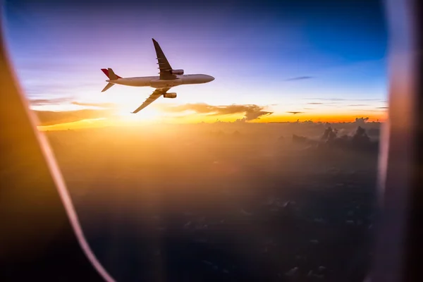 Airplane in the sky at sunrise — Stock Photo, Image