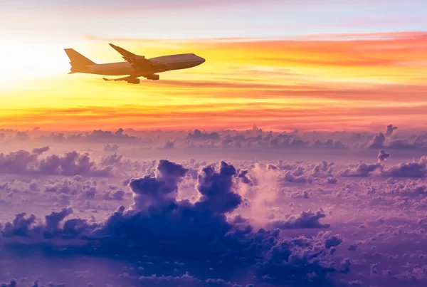 Airplane in the sky at sunrise — Stock Photo, Image