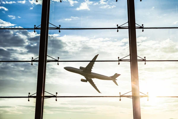 Окна аэропорта и самолет на закате — стоковое фото