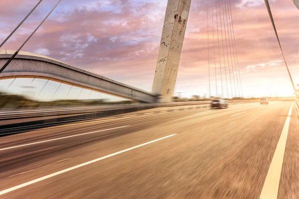 Desfoque de movimento da estrada ao pôr do sol — Fotografia de Stock