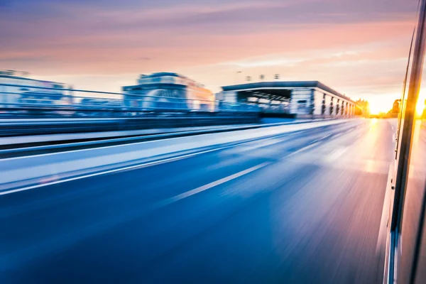 Carro dirigindo na auto-estrada ao pôr do sol, borrão de movimento — Fotografia de Stock