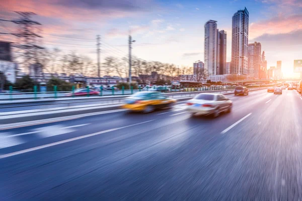 Car driving on freeway at sunset, motion blur — Stock Photo, Image