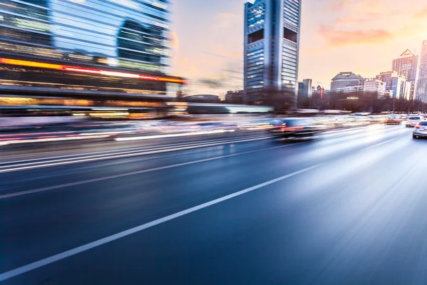 Coche conduciendo en la autopista al atardecer, desenfoque de movimiento — Foto de Stock