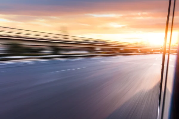 Auto fährt bei Sonnenuntergang auf Autobahn, Bewegungsunschärfe — Stockfoto