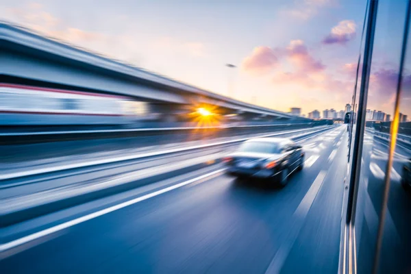 Autózás az autópályán naplementekor, mozgás elmosódás — Stock Fotó