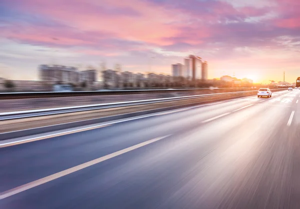 Jazda samochodem po autostradzie o zachodzie słońca, rozmycie ruchu — Zdjęcie stockowe