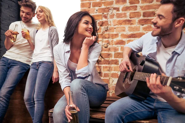 Молодая компания играет на гитаре — стоковое фото
