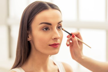 Güzel kız makyaj yapıyor.