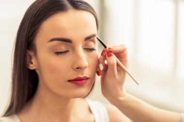 Güzel kız makyaj yapıyor.