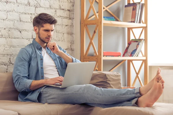 Jovem com gadget em casa — Fotografia de Stock