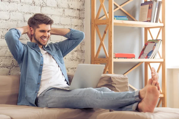 Jovem com gadget em casa — Fotografia de Stock