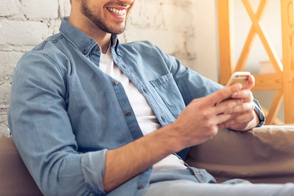 Young man with gadget at home — Stock Photo, Image