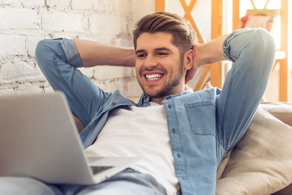 Jovem com gadget em casa — Fotografia de Stock