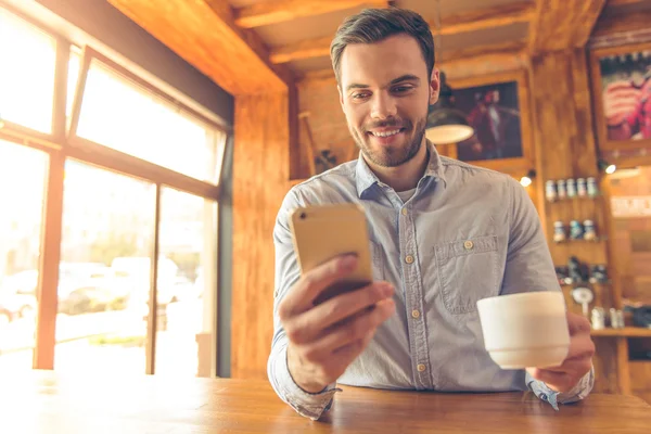 Jovem empresário com gadget no café — Fotografia de Stock