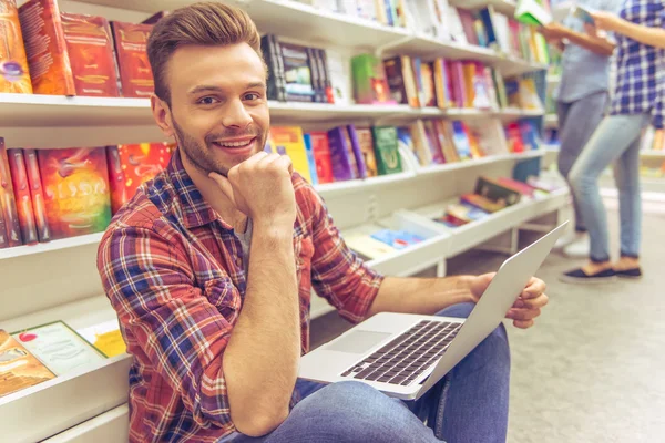 Studenten met gadget in de boekwinkel — Stockfoto