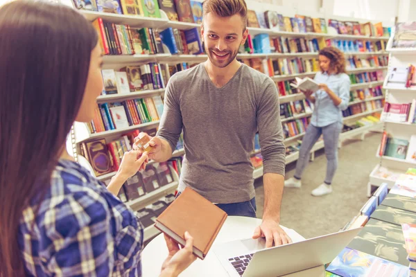 Man with credit card at the bookshop — Stock Photo, Image