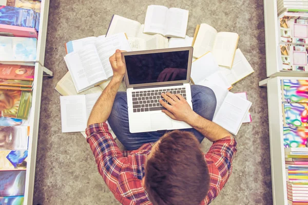 Tipo con gadget en la librería — Foto de Stock