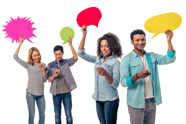 Students with speech bubbles and gadgets — Stock Photo, Image