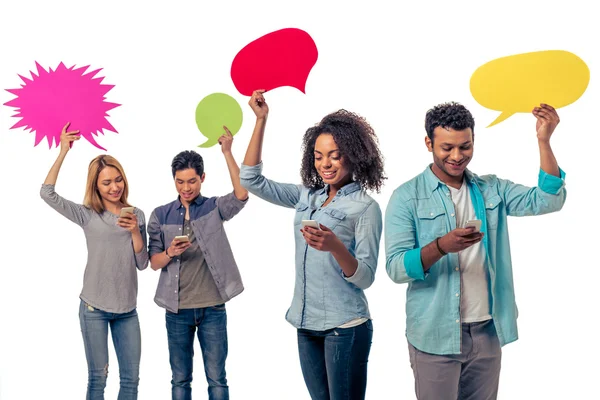 Students with speech bubbles and gadgets — Stock Photo, Image