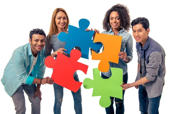 Young people with puzzles — Stockfoto