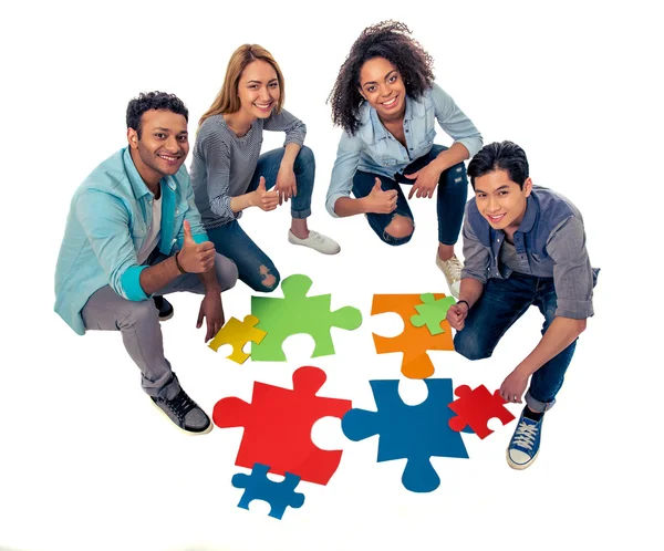 Young people with puzzles — Stockfoto