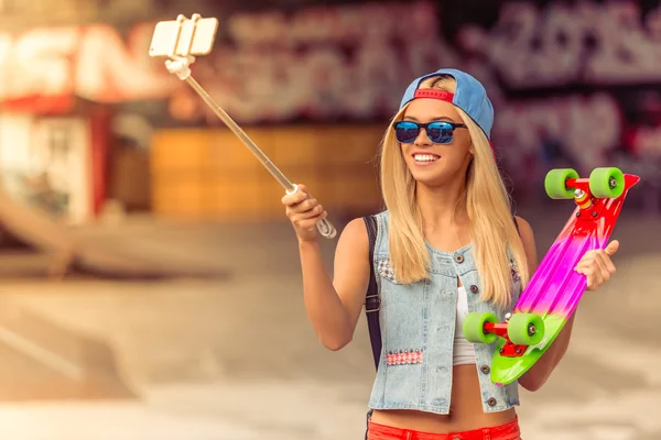 Skateboarding girl with gadget — Stock Photo, Image