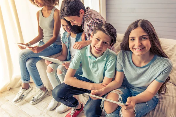 Adolescentes com gadgets em casa — Fotografia de Stock