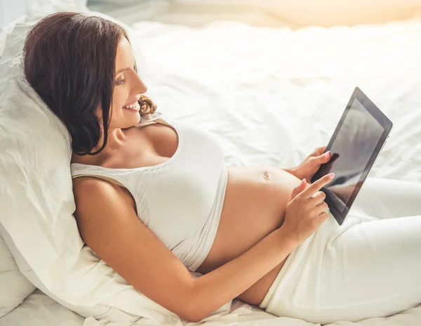 Hermosa mujer embarazada con gadget —  Fotos de Stock