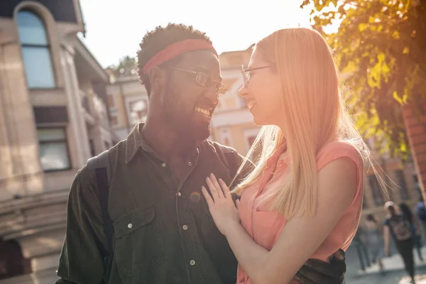 一对年轻快乐的夫妇 一个黑人男人和一个金发碧眼的女人在街上散步时拥抱在一起 — 图库照片