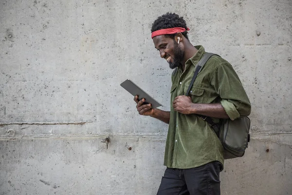 Jovem Negro Ouvindo Música Fones Ouvido Usando Tablet Eletrônico Enquanto — Fotografia de Stock