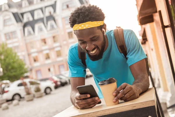 Jovem Negro Bebe Café Escreve Uma Mensagem Seu Telefone Enquanto — Fotografia de Stock