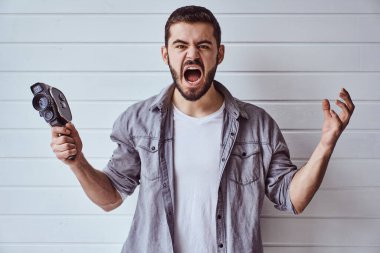 Genç duygusal bir adam arka planda eski bir kamerayla çekim yapıyor.