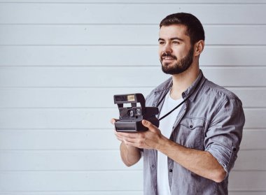 Genç duygusal bir adam arka planda eski bir kamerayla çekim yapıyor.
