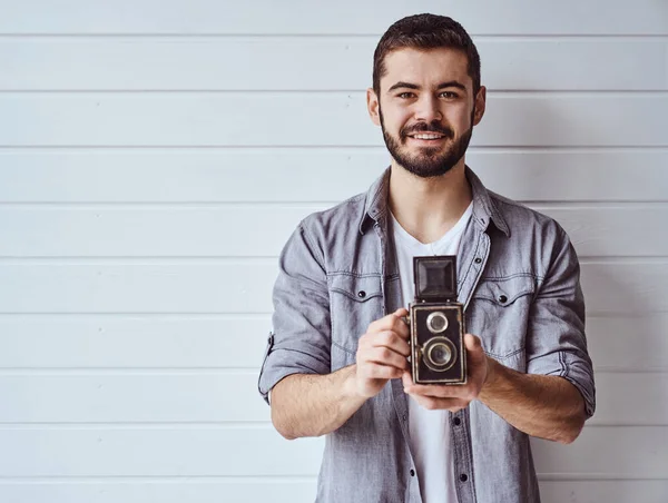 Νεαρός Συναισθηματικός Άντρας Ενώ Τραβάει Παλιά Κάμερα Στο Φως Φόντο — Φωτογραφία Αρχείου