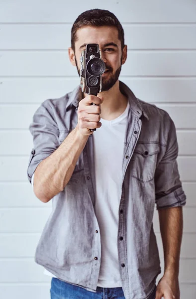 Joven Hombre Emocional Mientras Dispara Con Cámara Vieja Sobre Fondo —  Fotos de Stock