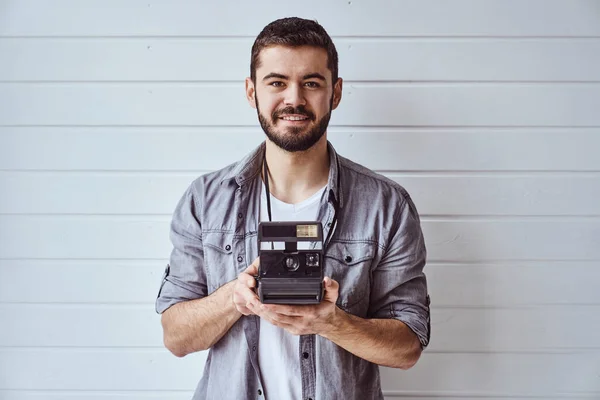 Joven Hombre Emocional Mientras Dispara Con Cámara Vieja Sobre Fondo — Foto de Stock