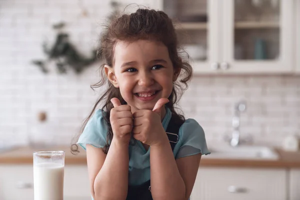 Щаслива Маленька Дівчинка Щасливо Посміхається Коли Смачне Молоко Склянки Сидячи — стокове фото